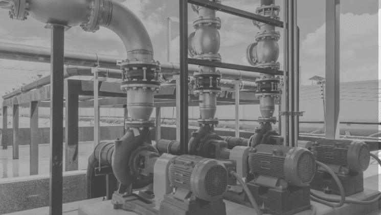Close-up of industrial centrifugal pumps and piping system used in critical plant operations and maintenance.